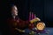 A young clairvoyant and fortuneteller reads the future on a mirror ball in a magic salon on a black background.