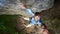Young climber smiling, hanging on rope on rock. Man falling down from the cliff holding friend`s hand