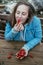 Young closed eyes woman eating strawberries in the nature on a b