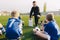 Young Coach Explaining Soccer Positions and Match Tactics to Youth