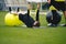 Young Coach Showing to Junior Players How to Exercise Properly on Training Mat and Training Yoga Ball