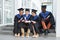 Young college graduates sitting on steps together