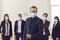 Young company leader with group of responsible workers wear face masks in their workplace