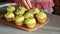 Young confectioner decorates cupcakes with lemon cream and grape close up