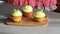 Young confectioner decorates cupcakes with lemon cream and grape close up