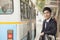 Young, confident businessman waiting at the bus stop for the bus in Beijing, China