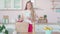 Young confident Caucasian woman entering kitchen with purchases. Portrait of beautiful housewife returning home from