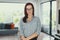 Young confident modern nerd woman posing in living room