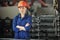 Young confident woman in hardhat, gloves and blue workwear looking at you