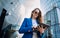 Young confident woman in suit using tablet. Dark atmosphere. Businesswoman walking to office.