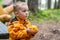 Young Confused Boy Holding Small Carved Pumpkin