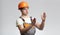 Young construction worker in hard hat and overalls manage building work process showing size with hands gestures on studio
