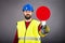 Young construction worker with hardhat stopping traffic ,holding a stop sign