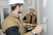 Young construction worker with long trowel plastering wall