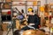 Young contemporary musician using shaker while sitting in front of drum kit