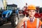 Young contractor shows blue agricultural tractor