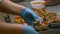 Young cook is putting meat dish in plates at table in restaurant kitchen irrl.