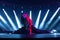 Young cool female performer doing a split on an illuminated stage