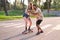 Young cool tattooed man teaching his girfriend how to skateboarding.