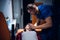 Young corpsman applies an oxygen mask to an injured woman lying on a stretcher in an ambulance car