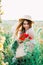 Young countryside girl sitting in the field of poppies