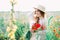 Young countryside girl sitting in the field of poppies