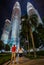 Young couple admire Petronas Towers at night Kuala Lumpur Malaysia