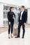 Young couple in an airport about to take a plane, looking timetables