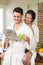 Young couple in bathrobe having tea and reading newspaper