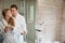 Young couple in the bathroom with coffee in their hands