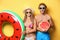 Young couple in beachwear with inflatable ring and watermelon