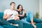 Young couple beautiful brunette woman and handsome man watching scary movie on the sofa eating pop corn looking