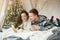 Young couple beautiful woman and handsome man both wearing warm sweaters reading recieved greetings in room decorated for