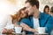 Young couple beautiful woman and handsome man drinking coffee in cafe hugging, love and tenderness concept