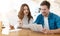 Young couple beautiful womanand and her handsome man holding menu choosing what to eat in cafe during lunch time break, food and