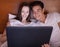 Young couple in bed with laptop