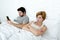 young couple in bed unsatisfied wife bored frustrated and angry while internet addict husband is using mobile phone social networ