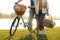 Young couple with bicycle and picnic basket near lake on sunny day