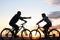 A young couple on bikes riding towards each other