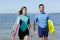 Young couple bodyboard surfers walking