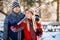 Young couple bring skis on shoulder