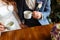 Young couple in a cafe in the attic drinking coffee and tea, sitting. Morning breakfast at the hotel. Cropped image of couple in l