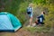 Young couple camping trip in forest at summer weekend. Travel, tourism, hike and people concept