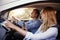 Young couple in car using smartphone to navigate their trip