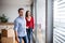 Young couple with cardboard boxes moving in a new home.