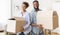 Young Couple Carrying Moving Boxes Into New House