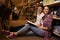 Young couple of cheerful students sitting on the floor and studying in the university library.