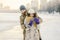 Young couple cheerfully flounders in snow. Between comic fight. Happy young couple hugs in winter snowy woods. Romantic