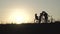 A young couple with a child kiss each other against the backdrop of sunset and ride their bicycles.