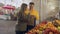 Young couple chooses many different fruits and them into a paper bag at the market